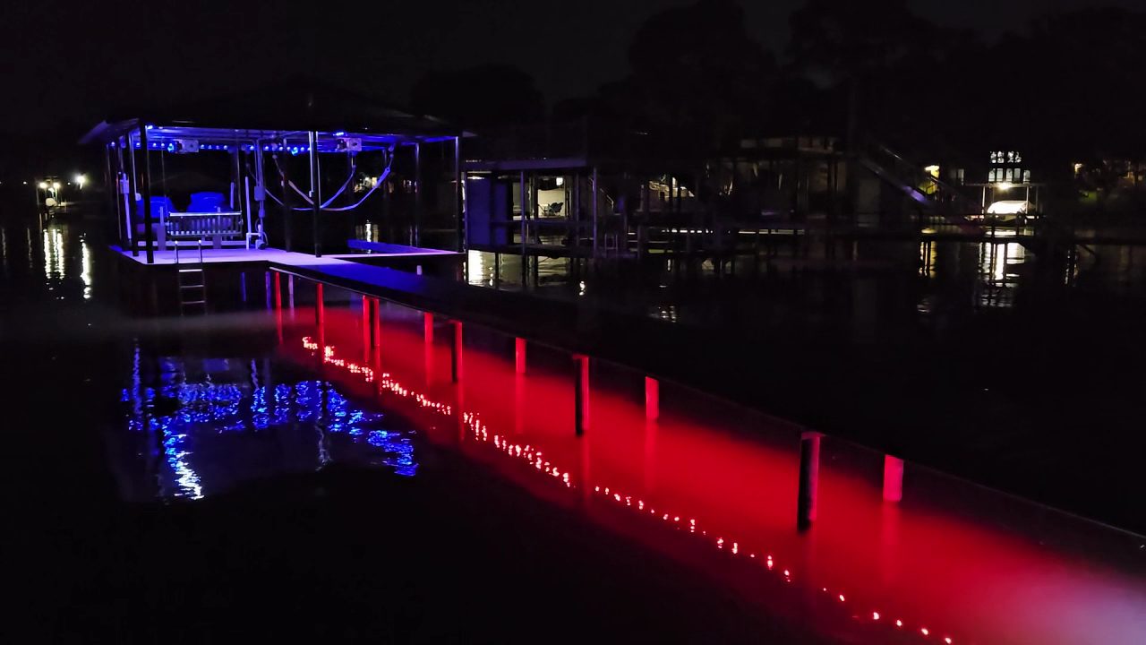 Dock lit red with reflections on the lake